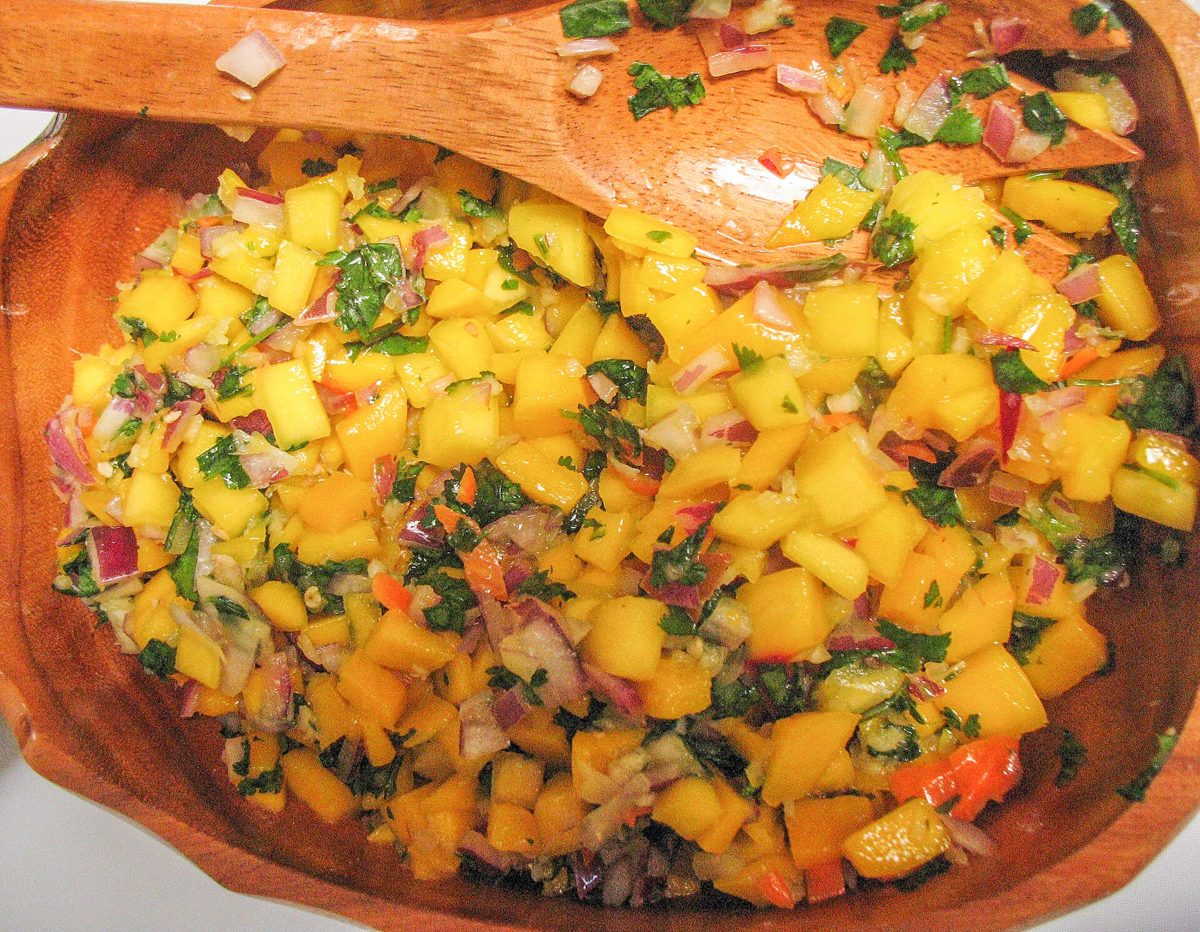 Bowl of diced mango salsa with red onion and herbs